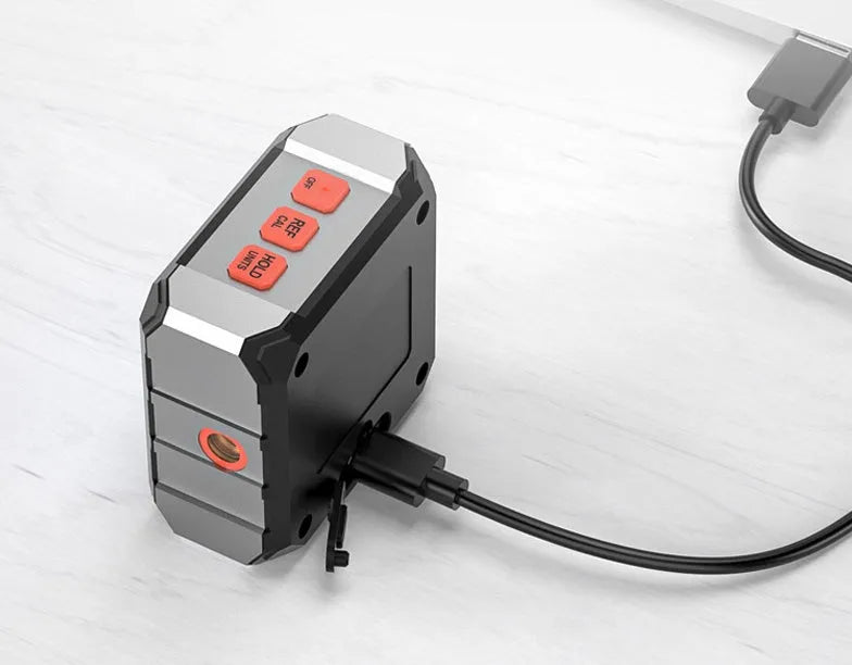 Longyun digital laser measuring tool with alloy casing and backlit display on a wooden workbench.