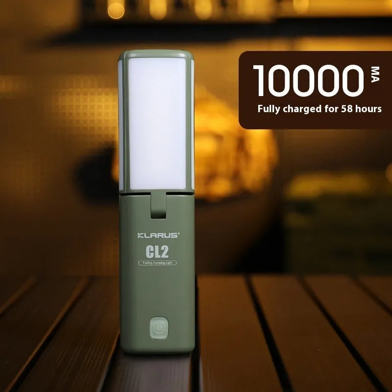 White and green rechargeable LED campsite lamp with charging cable on outdoor picnic table.