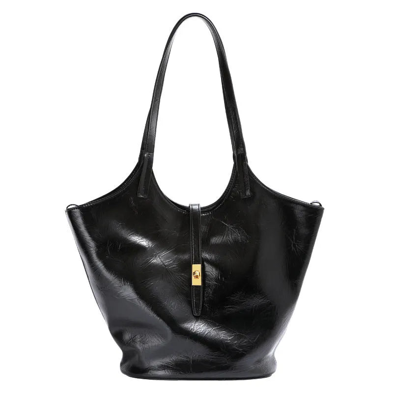 Black genuine leather large capacity bucket bag with visible stitching and crossbody strap on white background