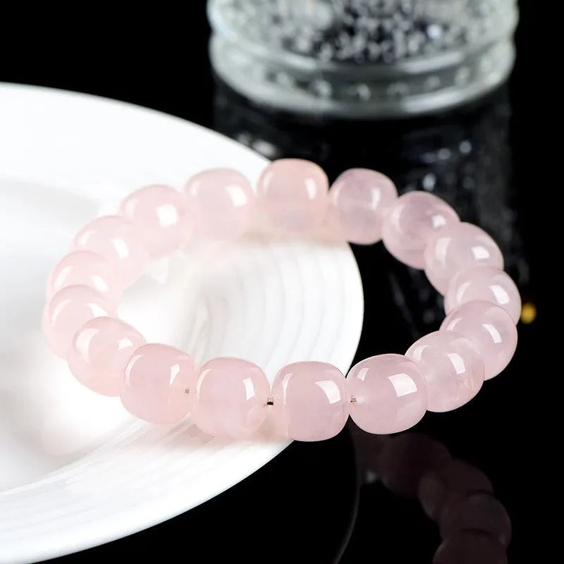 Pink crystal barrel bead bracelet with geometric design on a bamboo string.