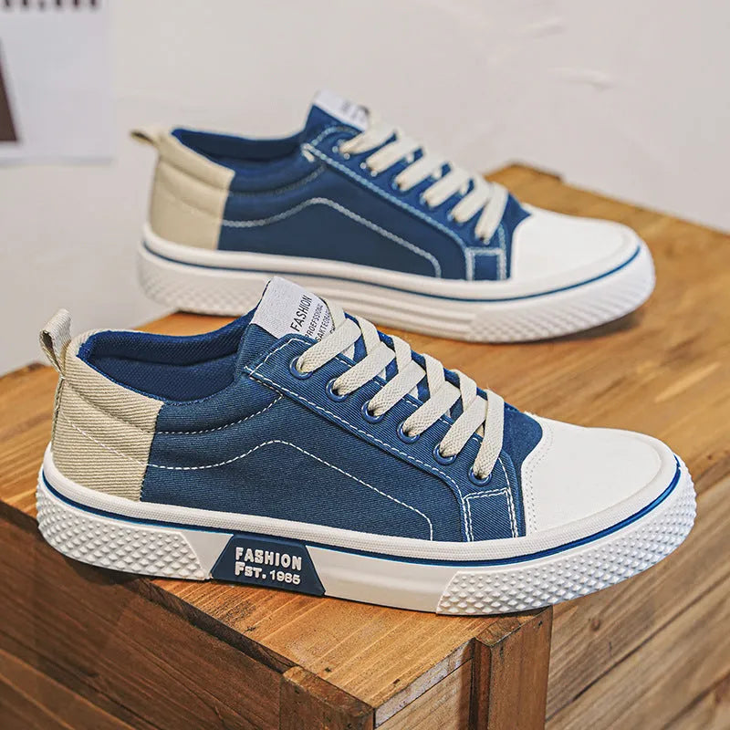 Men's low-top canvas shoes in blue with white sole and lace-up front, on a grey background.