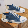 Men's low-top canvas shoes in blue with white sole and lace-up front, on a grey background.