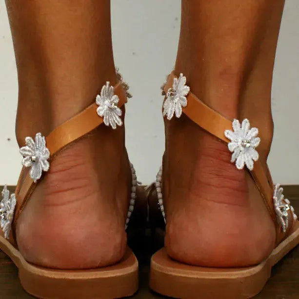Brown women's flat Roman sandals with floral pattern on the artificial PU upper.