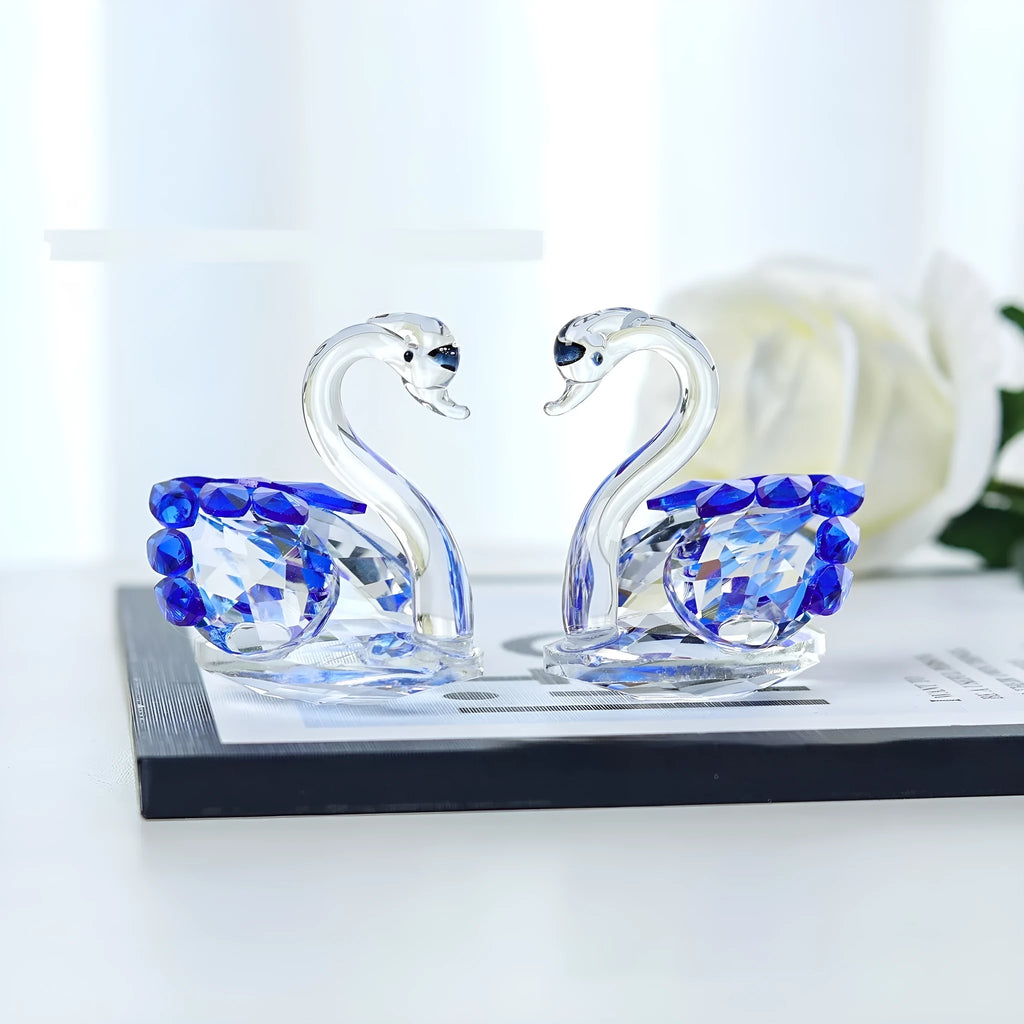 White crystal swan desktop ornament in red, blue, pink, or purple on a wooden surface.