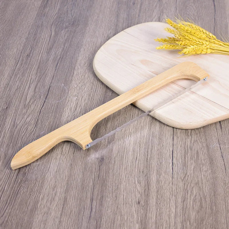 Wooden serrated bread knife with 40cm blade on a cutting board next to a loaf of bread