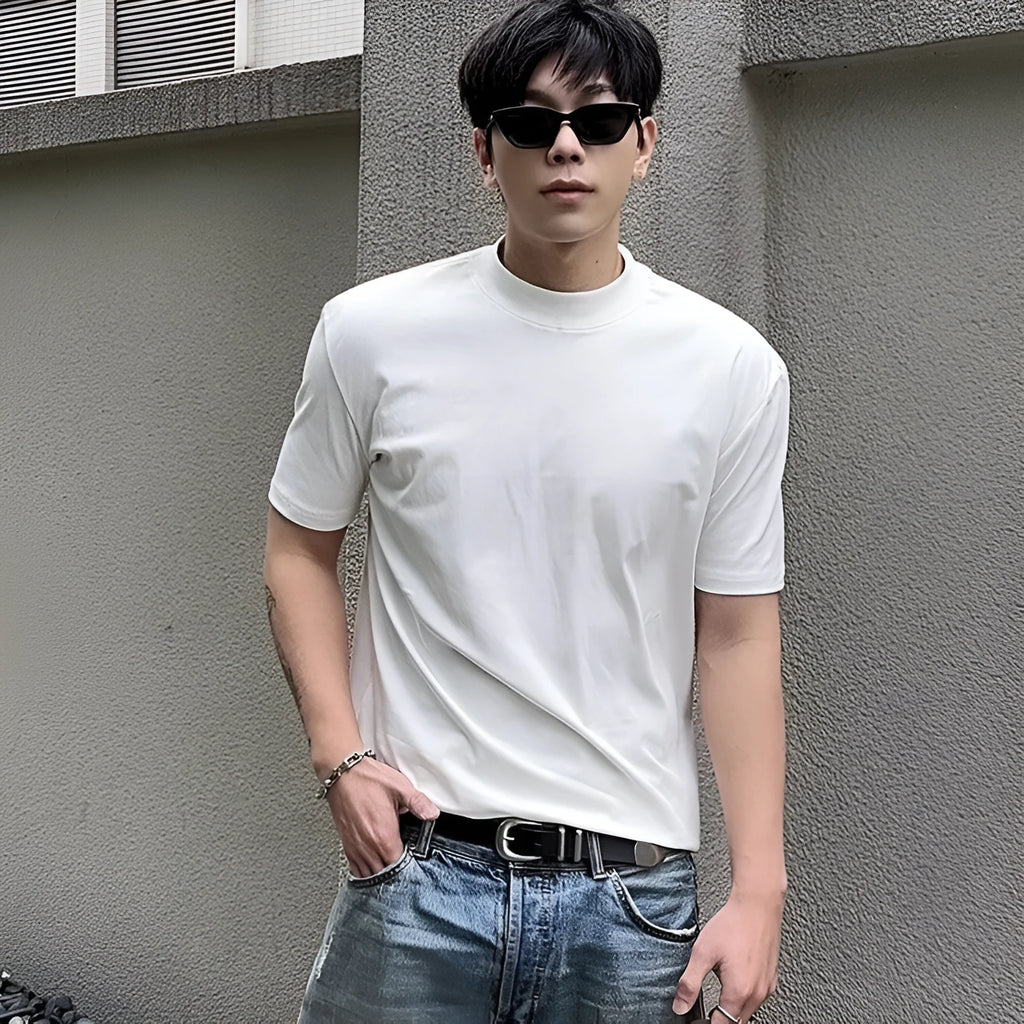 Man wearing a loose-fit grey cotton short-sleeve t-shirt with a half turtleneck cuff shoulder detail.