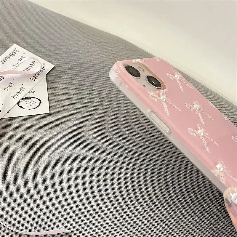 Pink soft TPU iPhone case with three-dimensional pearl dot bow, compatible with iPhone 11 to 15 Pro Max.
