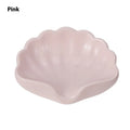 White plastic shell-shaped soap dish for bathroom vanity storage.
