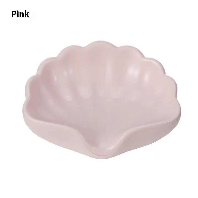 White plastic shell-shaped soap dish for bathroom vanity storage.