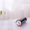 Black USB car humidifier with LED lights placed in vehicle cup holder showing mist output