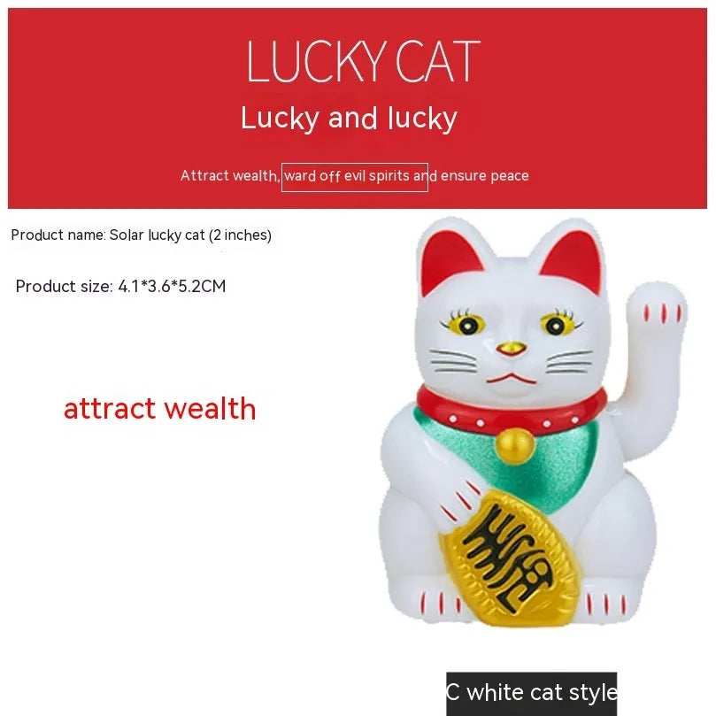 Yellow solar Maneki Neko lucky cat waving its arm on a car dashboard.