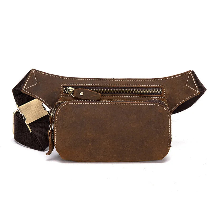 Brown top-layer cowhide men's sports waist bag shown with a 10-inch laptop and phone next to it for scale.