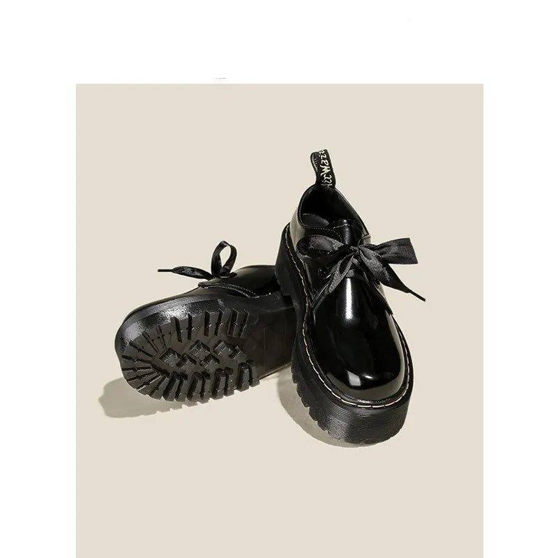 Black women's thick-soled lace-up shoes with decorative white ribbon cross straps.