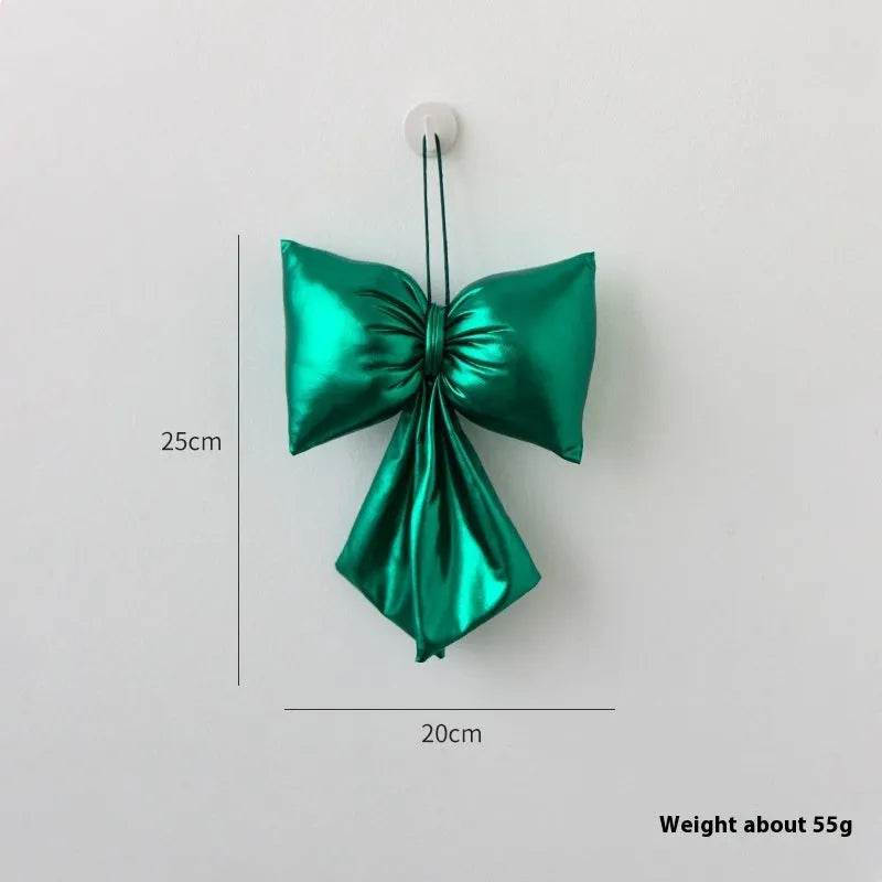 Christmas decorative bowknot with bright leather finish in red colour on a tree branch