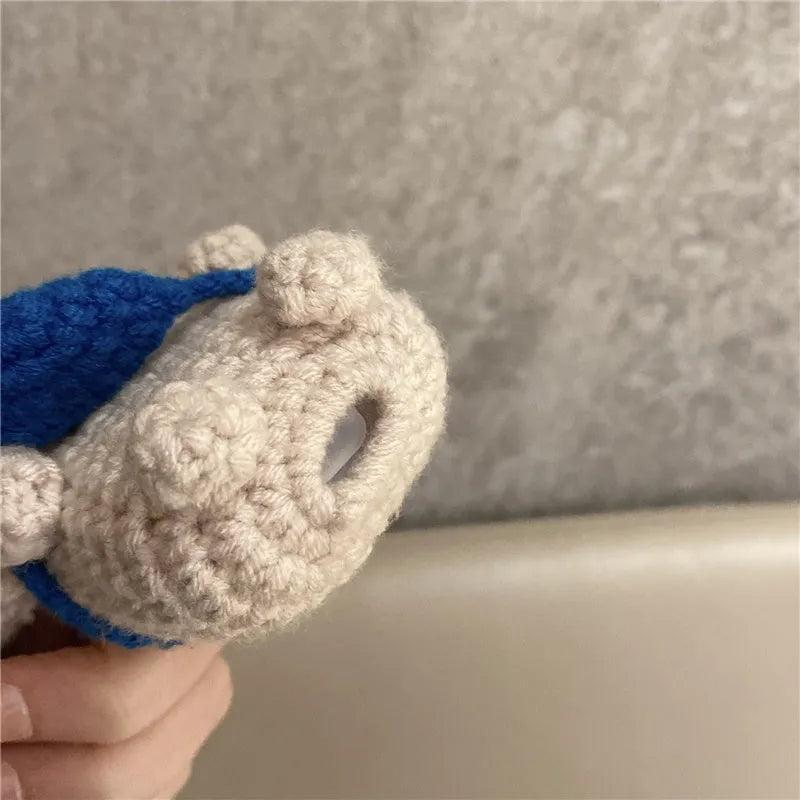 Handmade knitted koala bear backpack-shaped cover for an AirPods charging case.