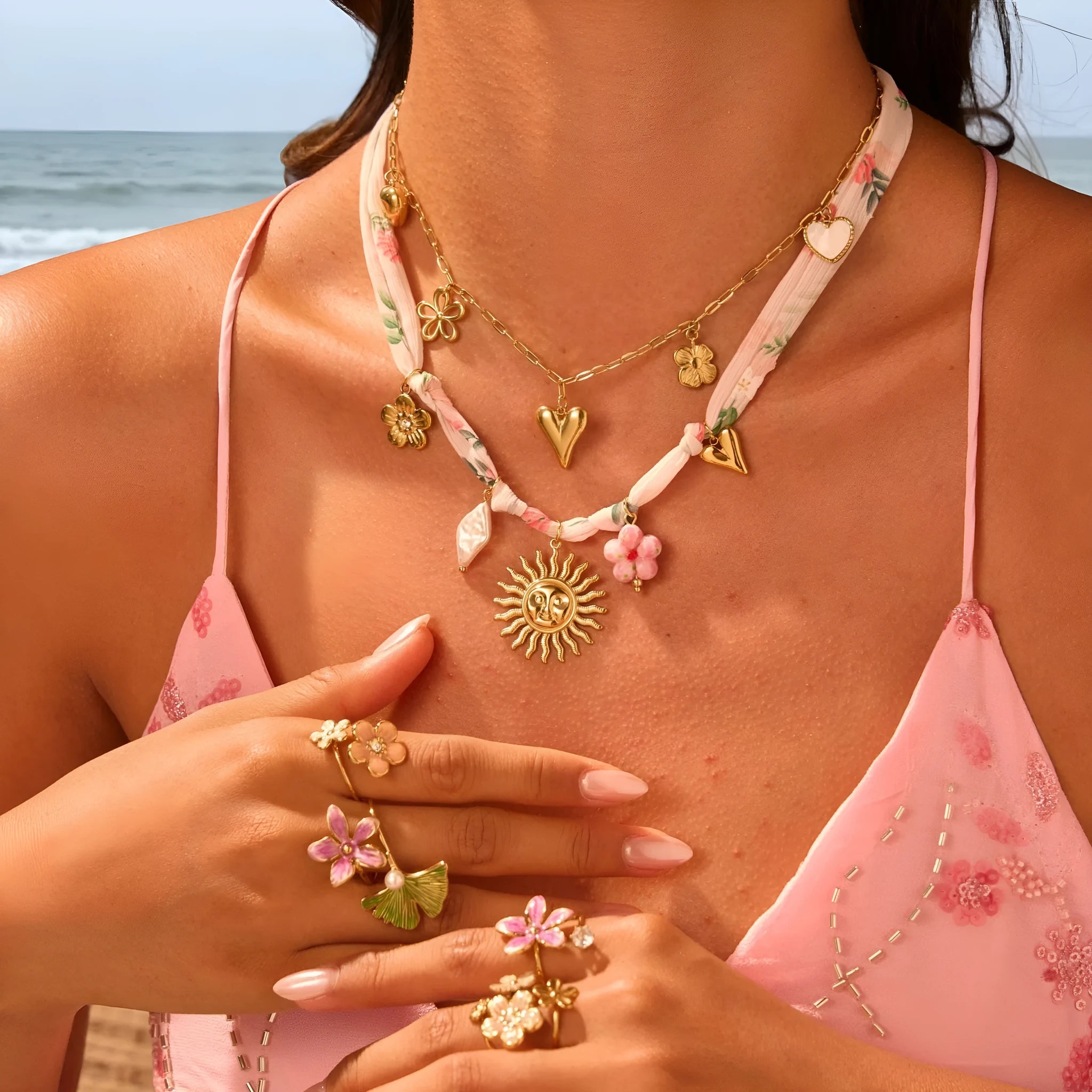 Stainless steel pendant necklace with 18K gold electroplating, showing heart and ribbon sun style options on an adjustable chain.