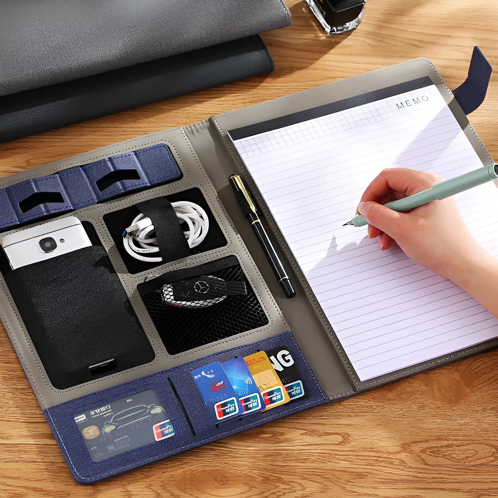 Black leather A4 business folder lying flat, showing its size and pen loop configuration