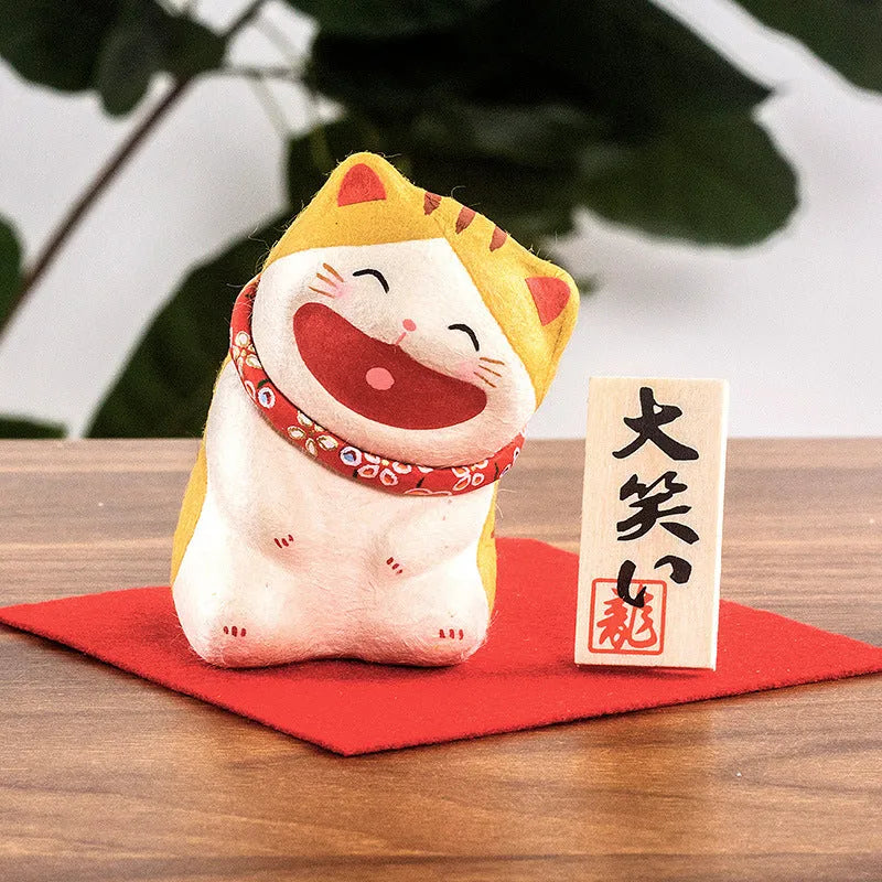 Handmade Japanese paper lucky cat figurine in Sanmao cat style, sitting on a car dashboard