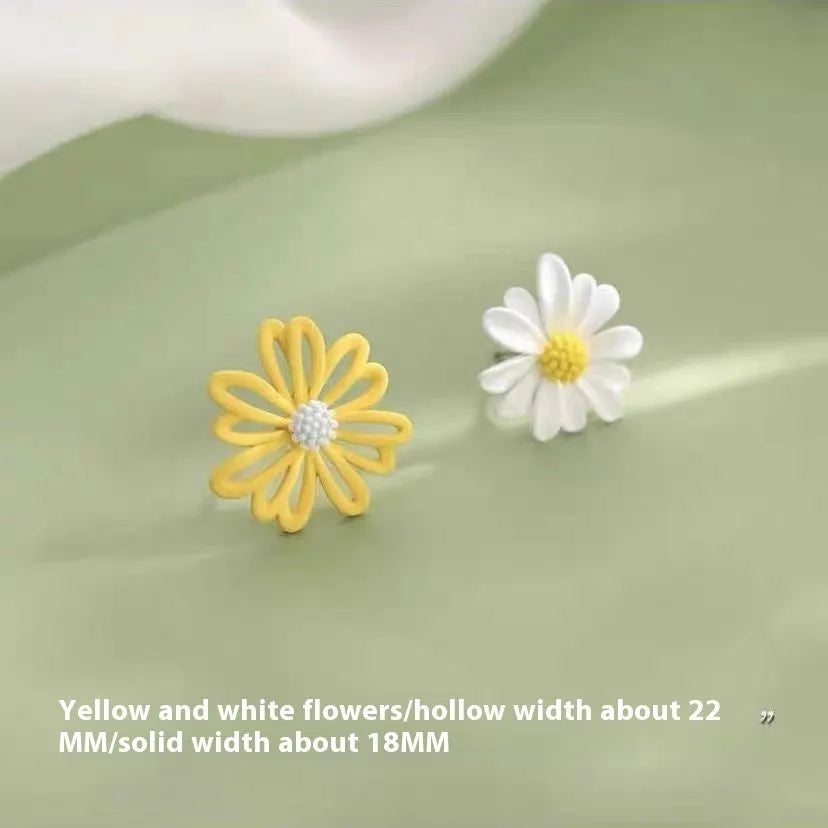 Close-up of colourful alloy flower stud earrings showing white and green two-tone design.