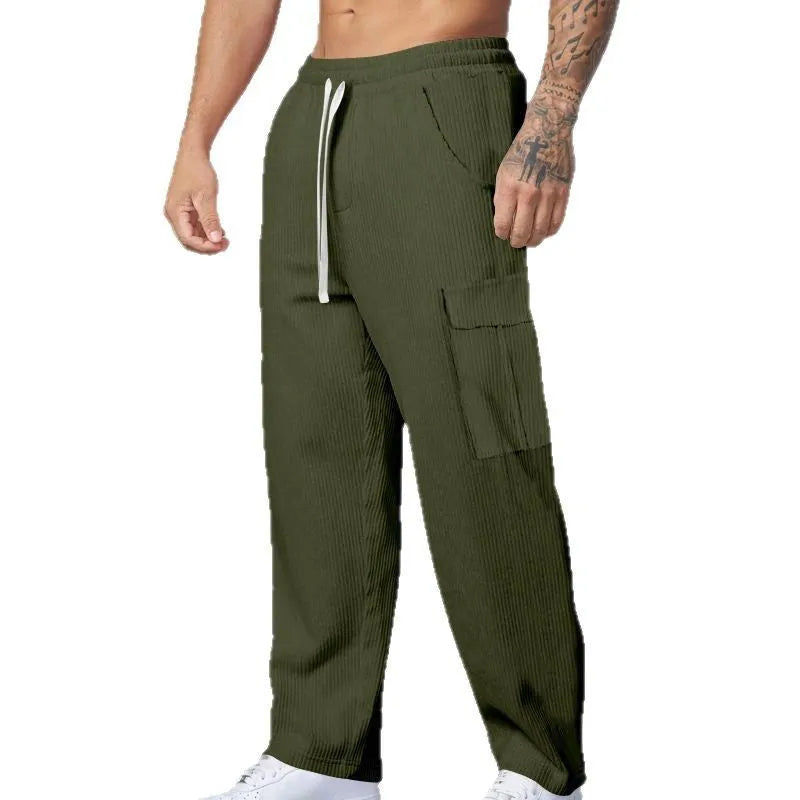 Men's loose-fitting corduroy cargo trousers in a brick red colour with a wide-leg silhouette.