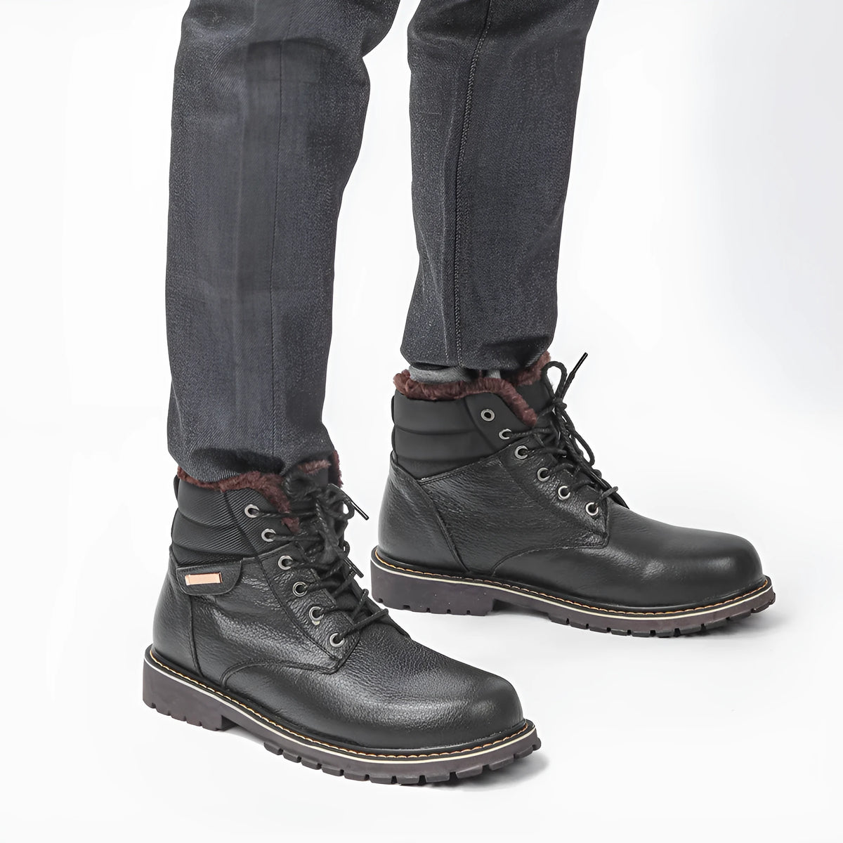 Pair of black plus size men's cowhide leather snow boots with fleece lining, mid-calf height and rubber sole.