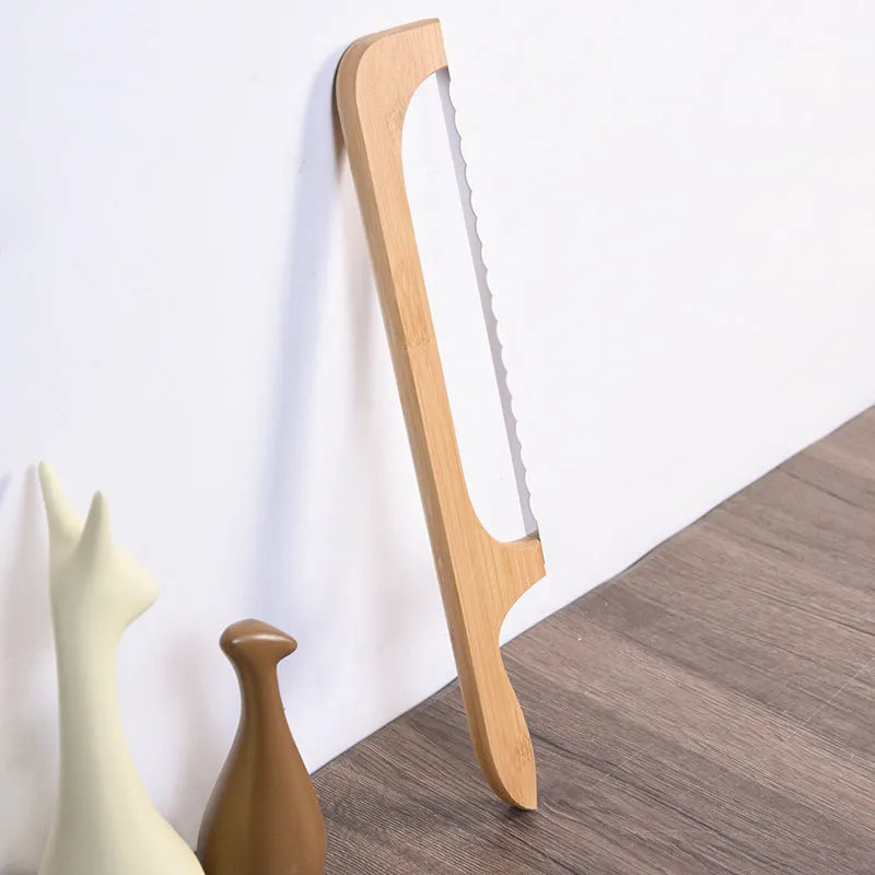Wooden serrated bread knife with 40cm blade on a cutting board next to a loaf of bread