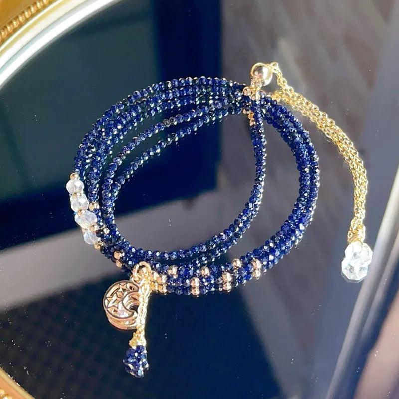 Women's three-ring layered bracelet with blue san stones in gold-toned settings, showing adjustable clasp