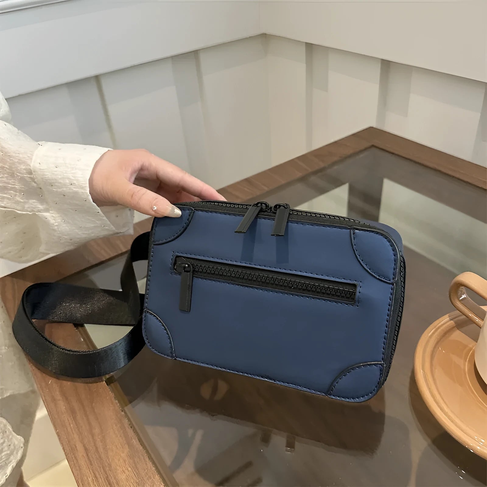 Women's black PU leather square crossbody bag with adjustable strap and outer pocket.
