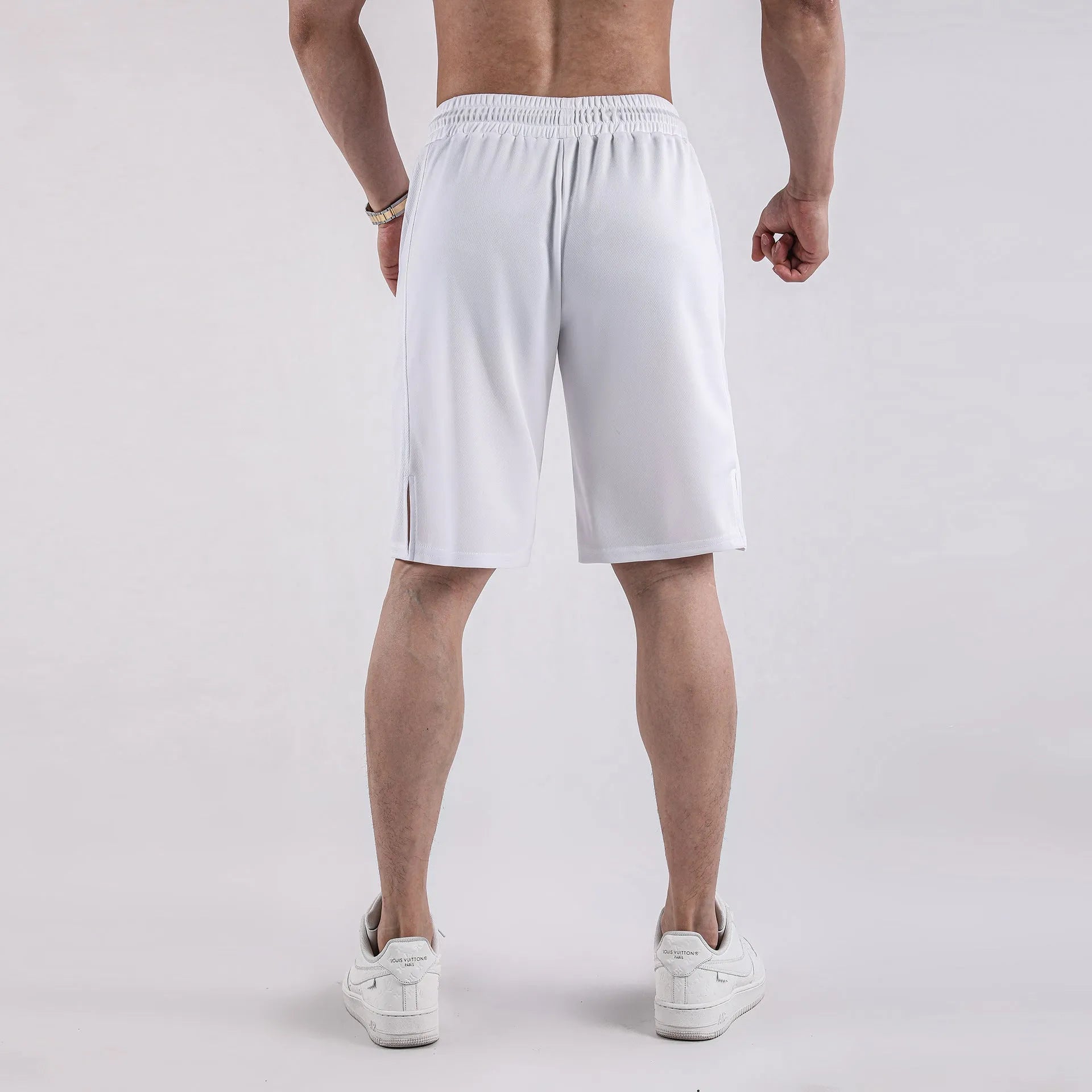 Man wearing loose-fit black quick-dry mesh shorts for casual summer sportswear.