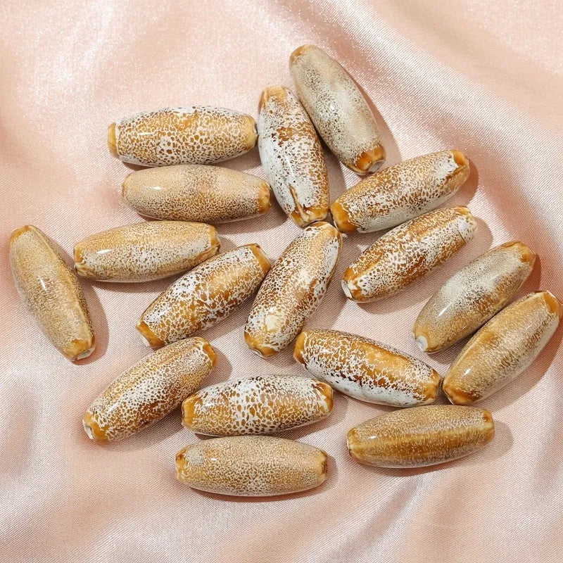 Assortment of ceramic bullet beads in pink, yellow, blue, red, coffee, green, orange, and mixed flower glaze colours.