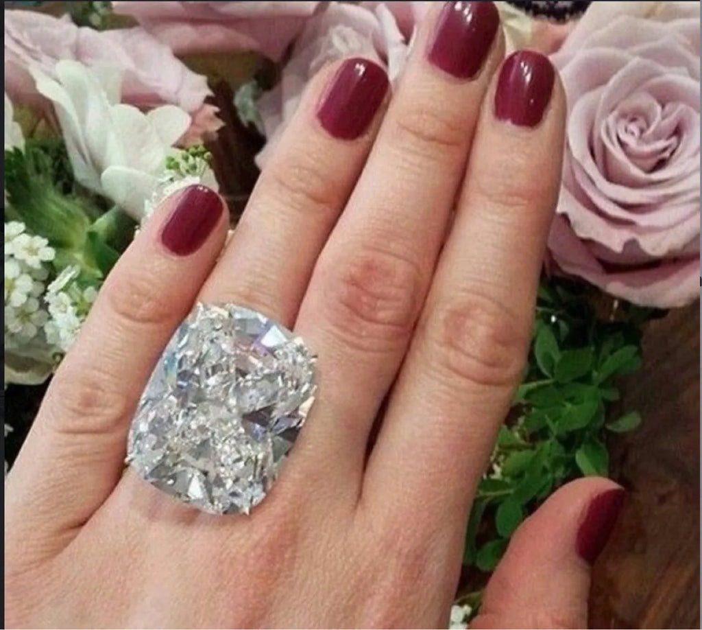 Simple women's alloy ring with an inlaid square diamond design in white gold colour on a model's finger.