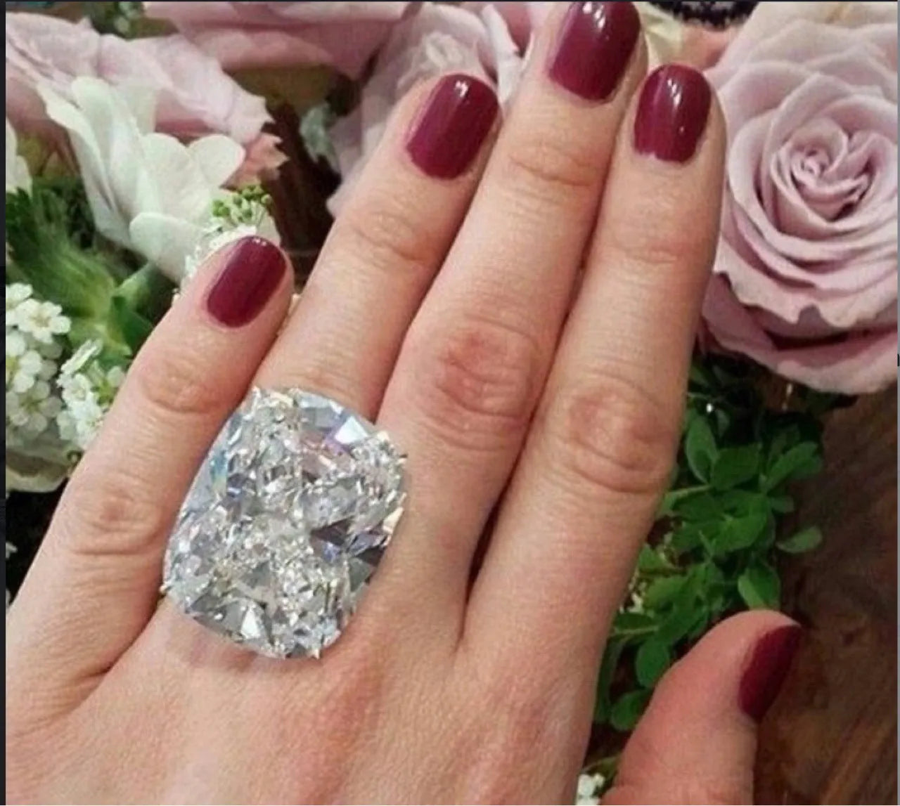 Simple women's alloy ring with an inlaid square diamond design in white gold colour on a model's finger.