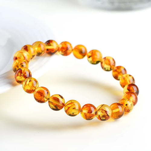 Natural yellow piebald amber geometric bracelet on a white background.