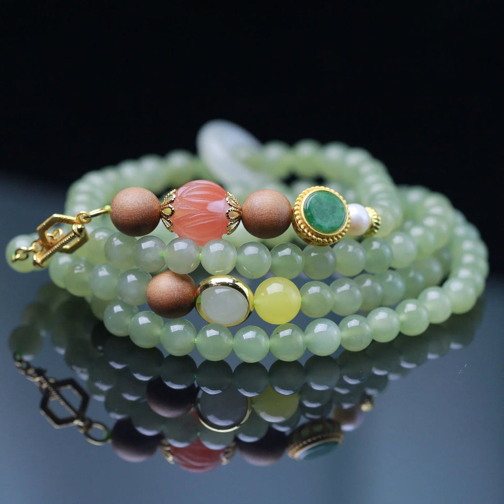 Handmade Hetian jade and white sandalwood necklace with red lotus beads and fu charm, shown with matching bracelet.