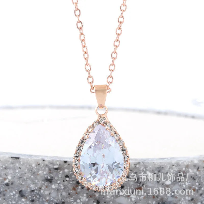 Rose gold water drop shaped necklace with geometric design and rhinestone accents in pink colour