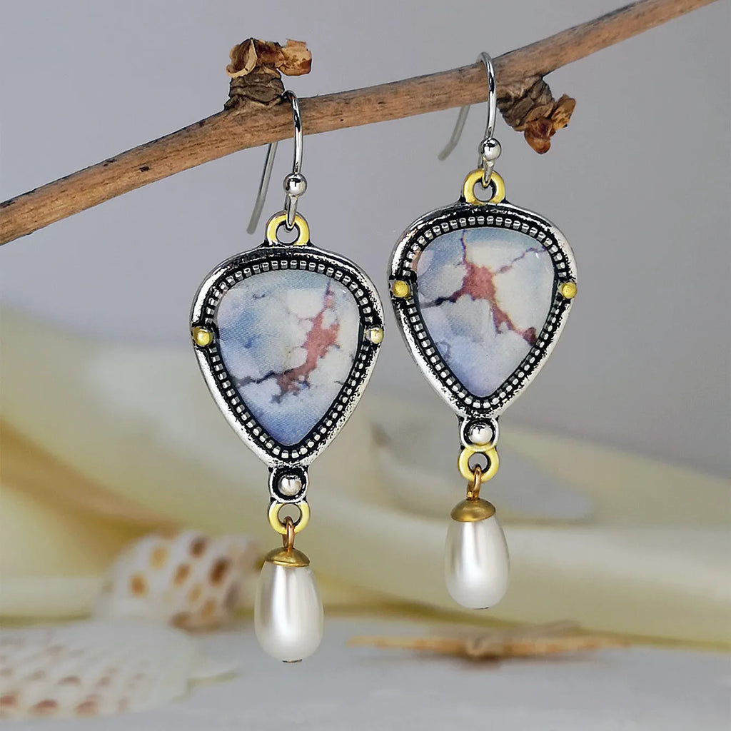 Retro blue geometric drop earrings with synthetic opal and pearl accents on white background