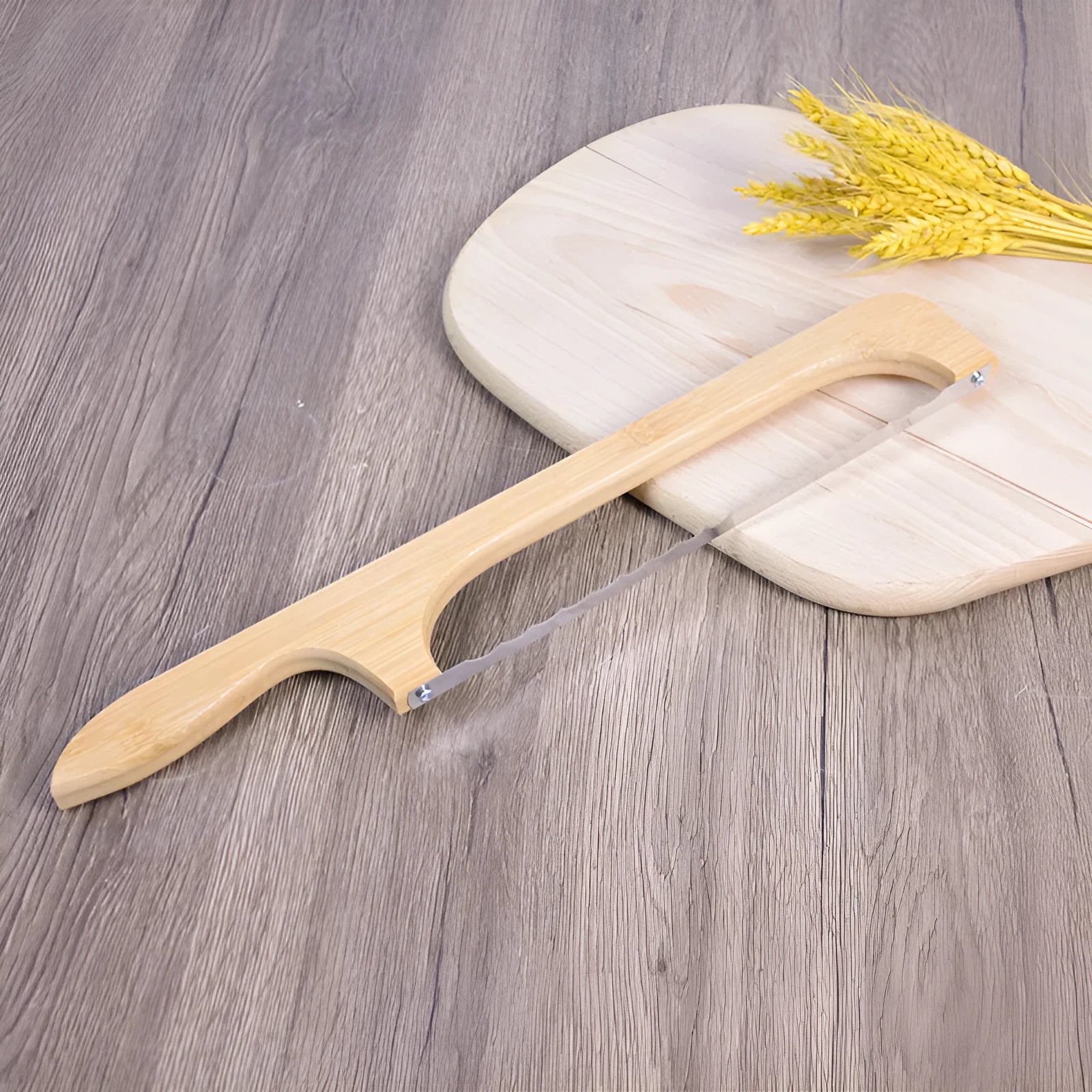 Wooden serrated bread knife with 40cm blade on a cutting board next to a loaf of bread