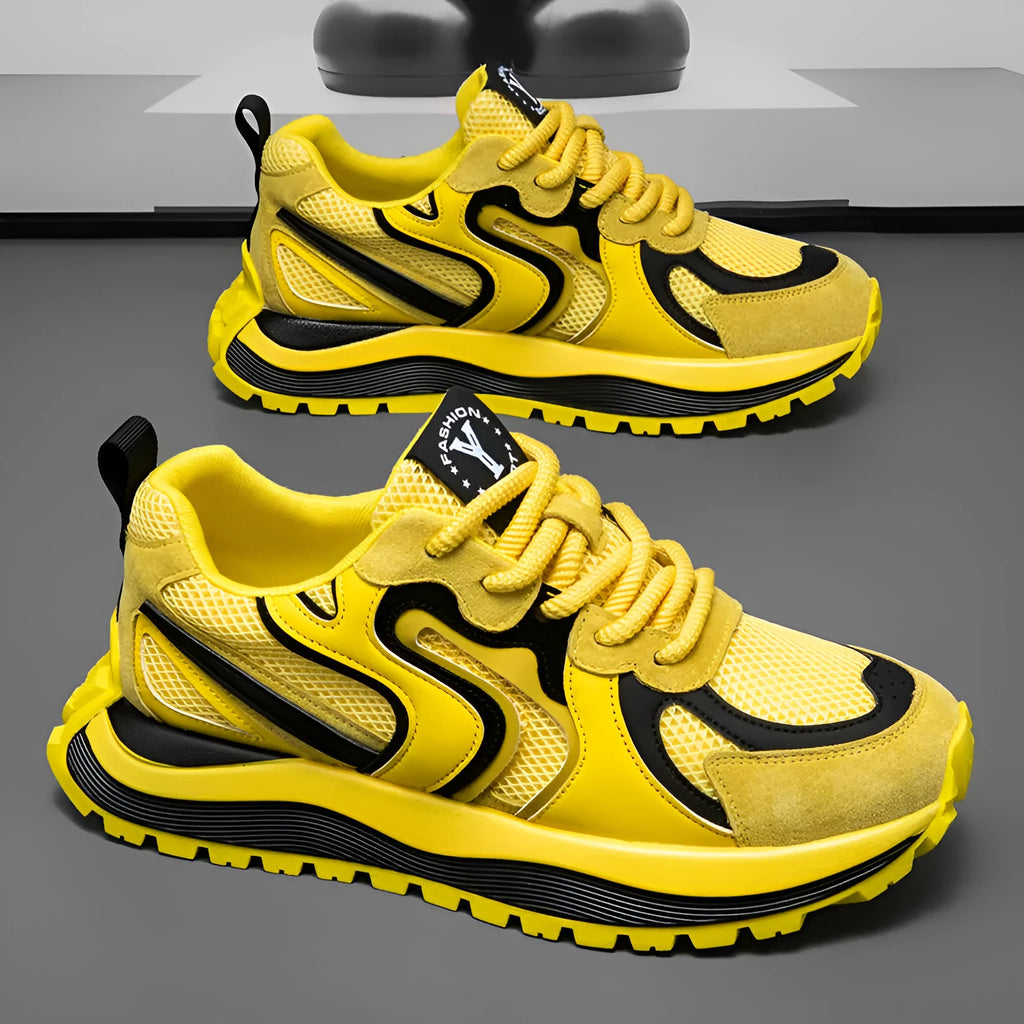 Men's casual sneaker in synthetic leather and mesh, showing round toe and lace-up front.