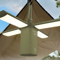 White and green rechargeable LED campsite lamp with charging cable on outdoor picnic table.