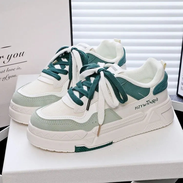 Beige children's lace-up trainers with cross straps over instep and thick rubber sole.