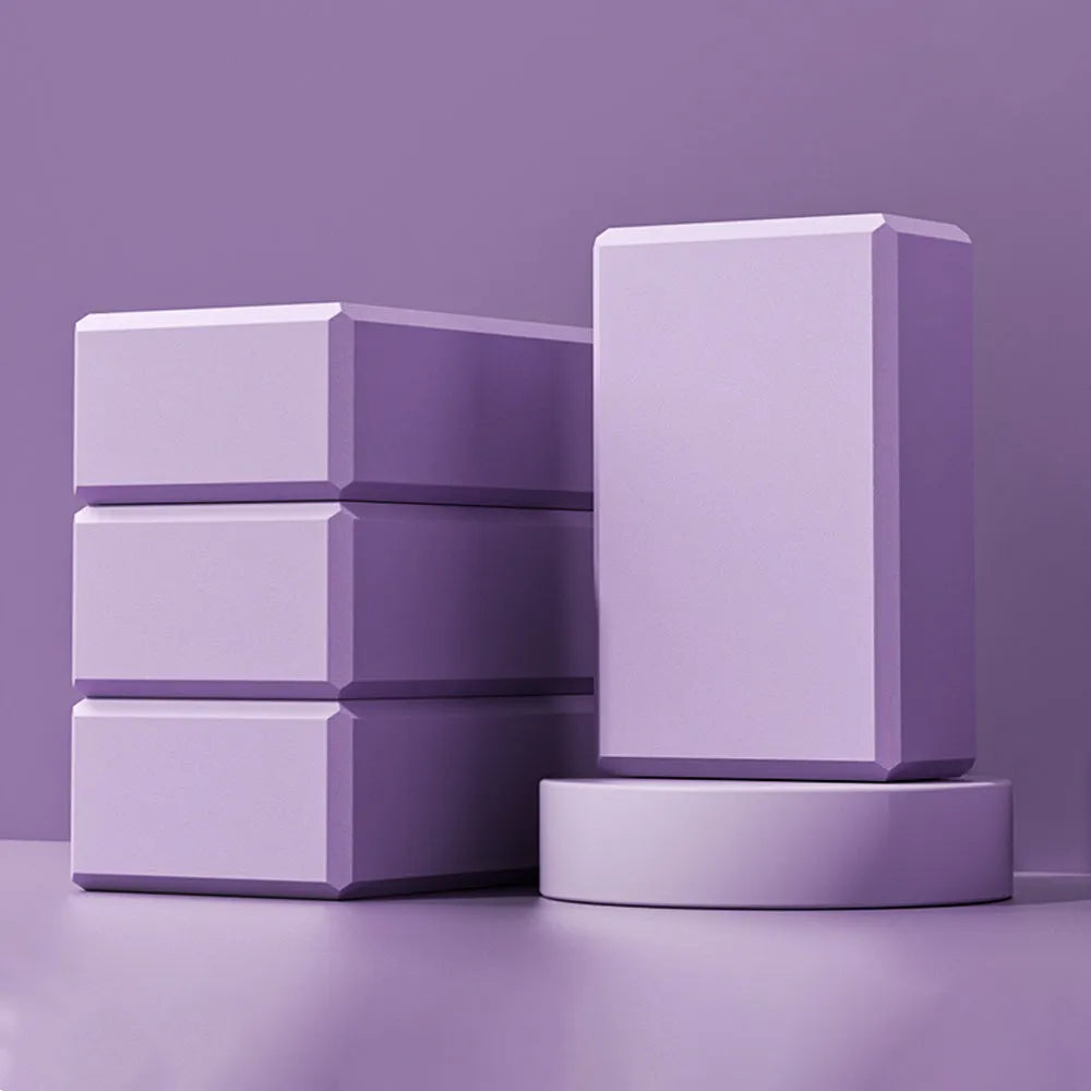 Solid colour high-density EVA yoga brick with hexagonal ridges on a gym floor.