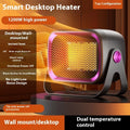 A compact grey desktop ceramic electric heater with a rotatable base on a wooden desk.