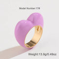 Heart-shaped zinc alloy ring with three-dimensional enamel colour in black, pink, purple, or red on a finger.