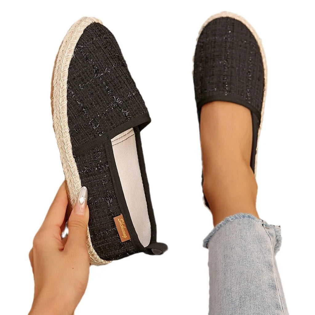Casual beige canvas fisherman shoes with a rope sole and flat heel on a plain background.