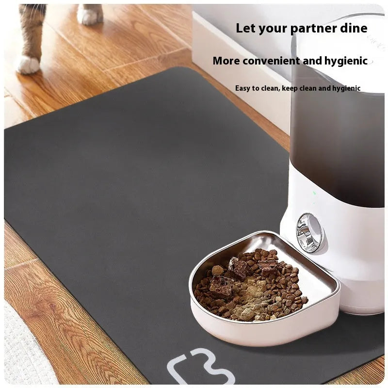 Pet feeding mat with non-slip backing in a dog paw print design on a hardwood floor.