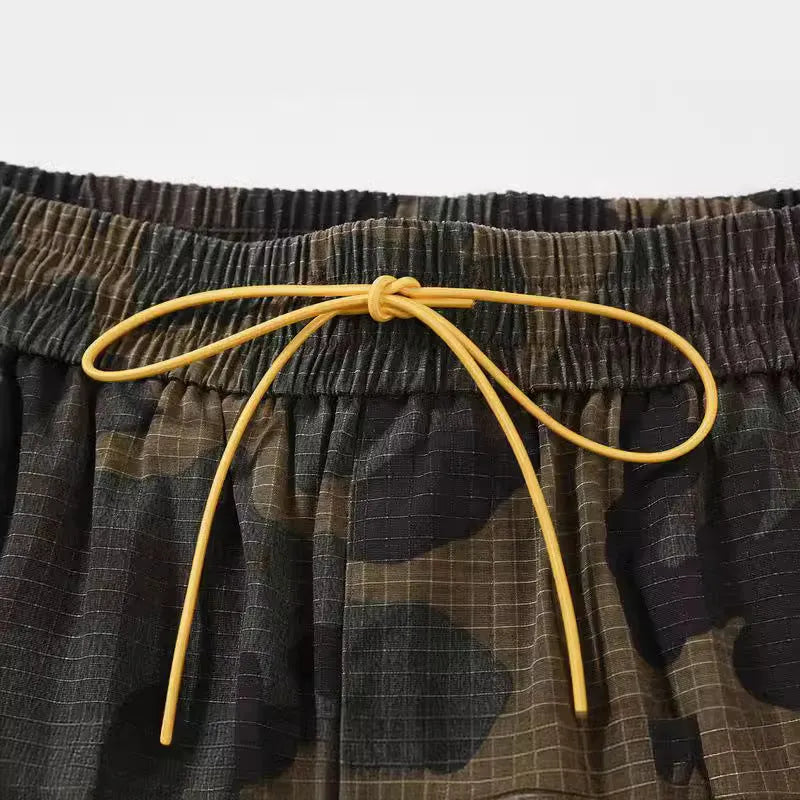 Men's green camouflage cotton work shorts with multiple pockets and a loose fit.