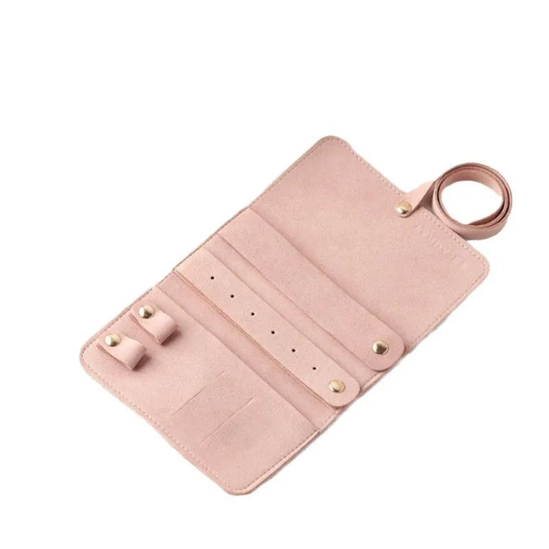 Brown PU leather jewellery storage pouch open to show microfiber lining, with earrings and a ring inside.