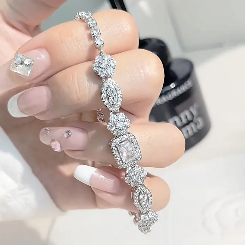 Close-up of women's geometric silver bracelet with sparkling cubic zirconia stones on a wrist, showing adjustable clasp.