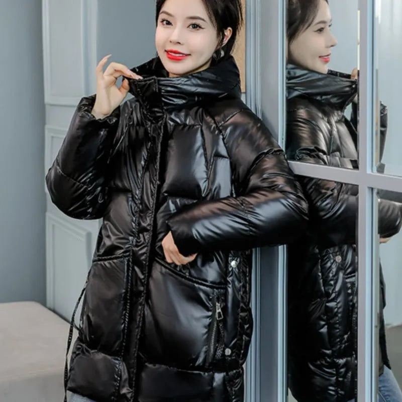 Women's green ultra-thin hooded winter jacket with long sleeves on a hanger.