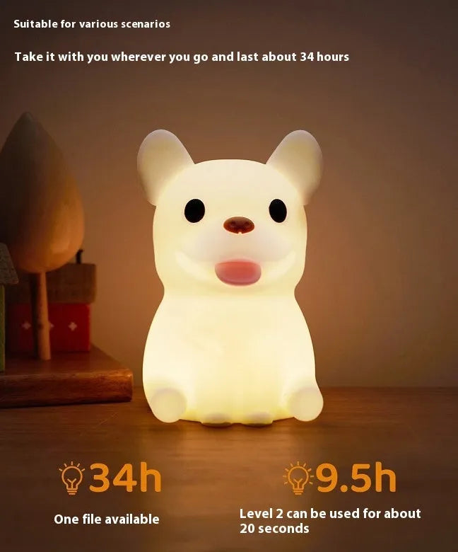 Soft silicone animal or cartoon-themed USB night light with dimming function on a bedside table.